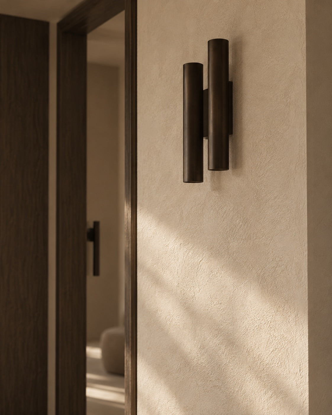 Detail van een donkere wandlamp en wandafwerking in Project Aerdenhout